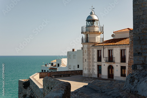 Peñíscola lighthouse beside the Papa Luna Castle overlooking the turquoise Mediterranean Sea, Costa del Azahar, Spain
