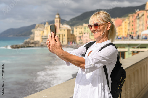 Canvas Print Senior woman traveling and taking selfie with phone in portofino