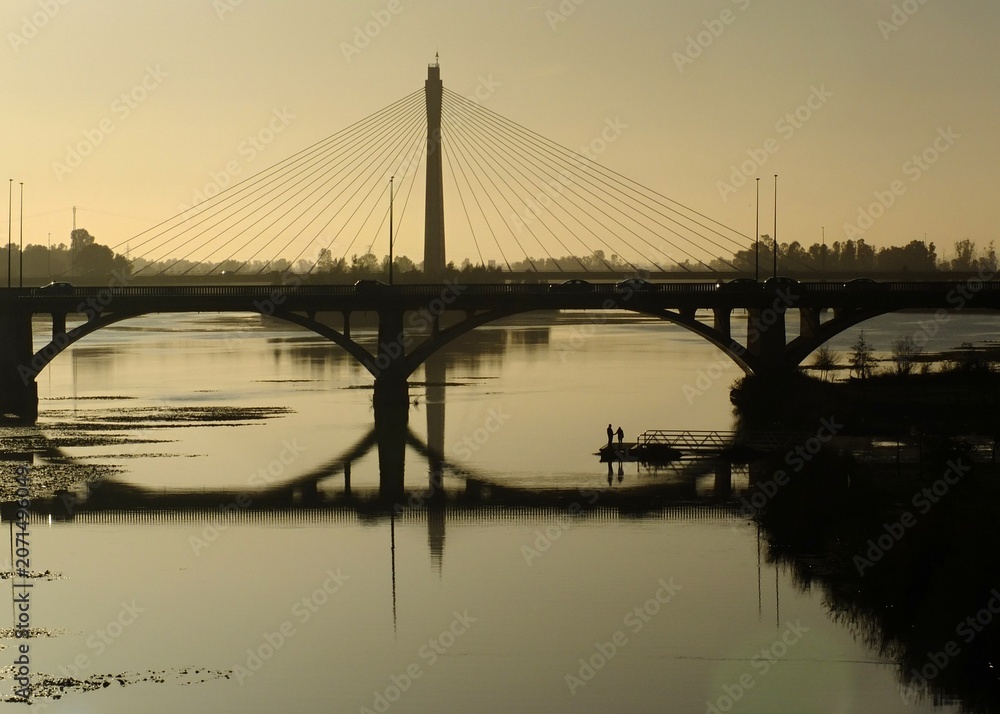 Fototapeta premium Guadiana river bridge reflecting during a golden sunset