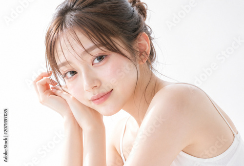 白い背景で微笑む若いアジア人女性の美容・スキンケアイメージポートレート