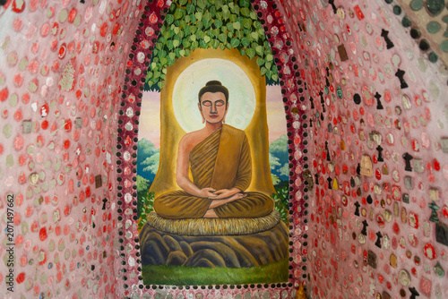 Canvastavla A painting of Buddha meditating in a shrine decorated with small offerings