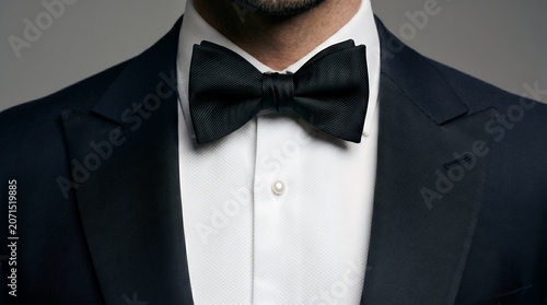 Elegant Black Bow Tie and Tuxedo Jacket Detail with White Shirt and Pearl Button