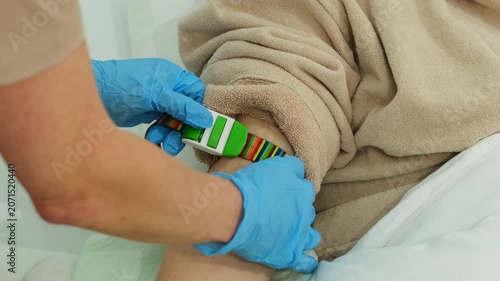 Doctor slowly tightens medical tourniquet around arm of patient preparing for sterile catheter insertion. Nurse improves vein visibility. Slow motion
