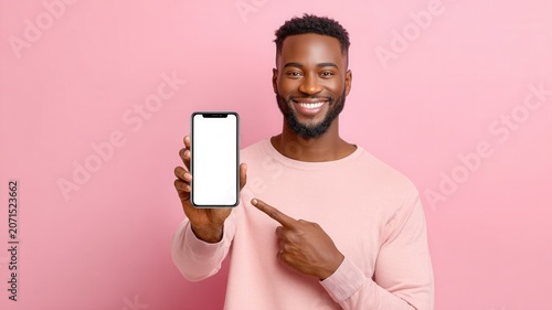 Happy black man pointing at smartphone showing empty screen for app promotion or new service
