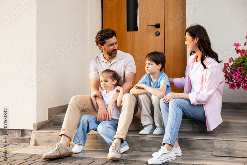 Tableau sur toile Family with two kids relaxing on home stairs