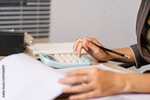 Foto Hands calculate finances with calculator and pencil