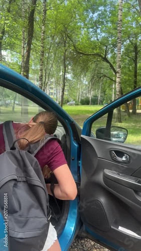 a girl with a small dog is traveling in the front seat of a car on a hot summer day, a child is sitting in a car on a hot day, traveling by car	