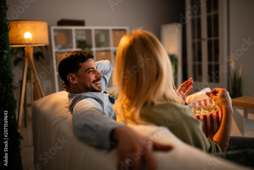 Obraz na plátně Couple enjoying movie night at home eating popcorn