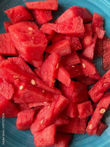 Fresh cut watermelon cubes in blue bowl, close-up