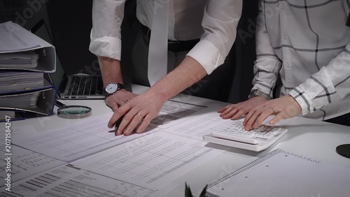 Konstfotografi Business professionals analyzing financial documents, using magnifying glass for