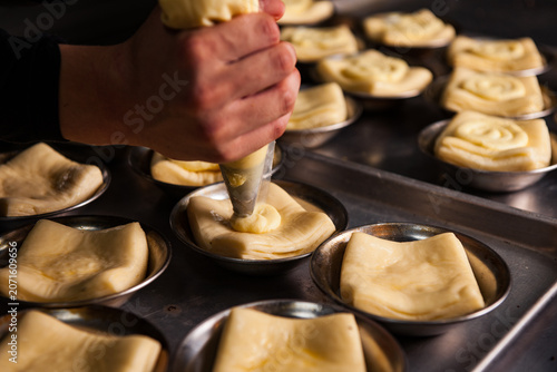 Obraz na płótnie Professional Pastry Chef Piping Cream onto Unbaked Dough