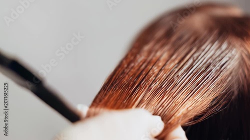 Professional hair coloring technique with brush on shiny brown hair texture