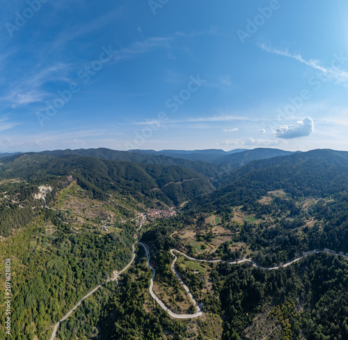 Experience the stunning beauty of hills and winding roads in this aerial view of mountain