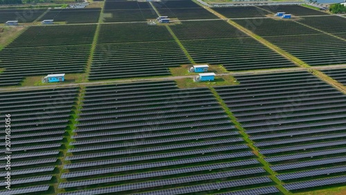 Schilderij op canvas Aerial drone view of a vast solar farm with aligned photovoltaic panels, reflecting the global push for renewable energy and reduced reliance on fossil fuels in today’s changing energy landscape
