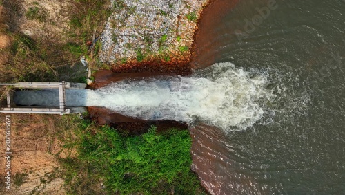Obraz na plátně Aerial drone view of water flowing through a concrete irrigation channel into a reservoir, highlighting efficient water management, agricultural sustainability, and controlled distribution systems