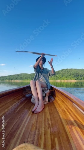 Woman paddling a canoe across a calm lake