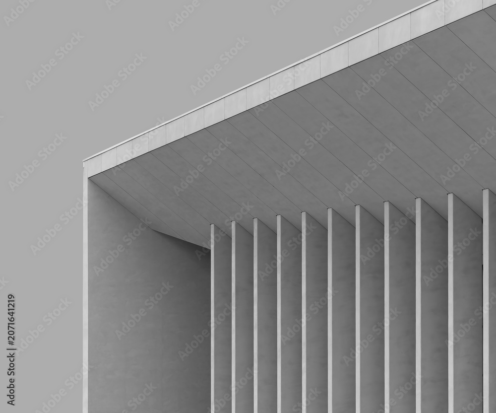 Naklejka premium Minimalist modern building facade with vertical concrete columns and sharp geometric lines. Clean monochrome architecture creates a contemporary