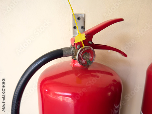 Canvastavla red fire extinguisher pressure gauge with yellow plastic safety seal, soft focus