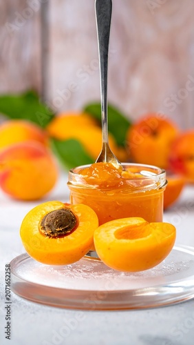 Sweet apricot preserve in a small jar with fruit