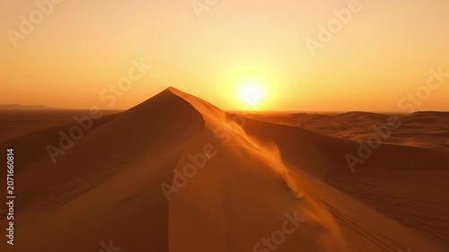 As the sun sets on the horizon, grains of sand swirl in the gentle breeze, creating a stunning visual symphony of textures and warm hues across the endless desert.
