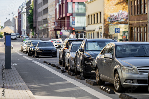 Obraz na płótnie Vehicles parked in designated street parking zones along an urban thoroughfare,