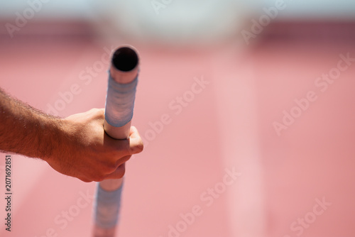 Pole vaulter prepares for jump, detail of vaulting pole