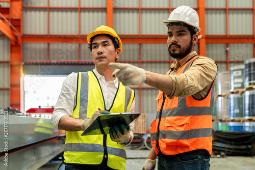 Foremen and factory workers are assisting in supervising work at a metal sheet factory.
