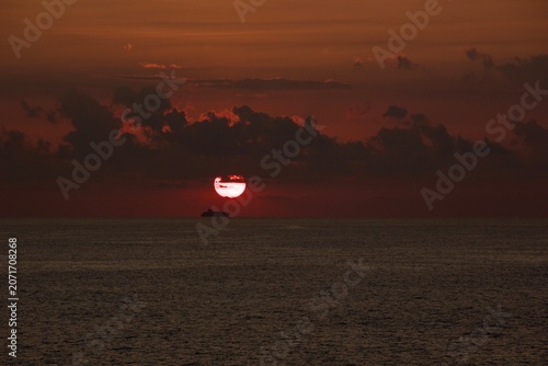 Dramatic Sunrise Over the Indian Ocean with Cargo Ship Silhouette