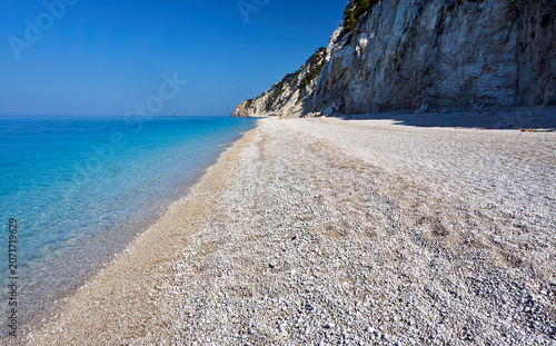 Foto An empty, pebbly beach at the foot of a rocky cliff on the island of Lefkada