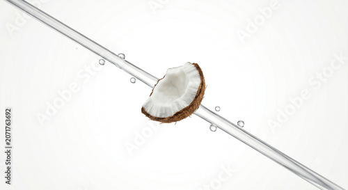 Distant shot of a coconut chunk with a sharp diagonal transparent water jet stream