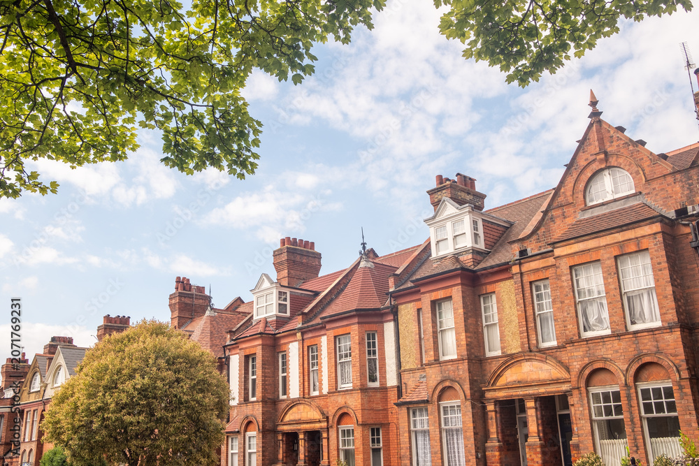 Obraz premium LONDON - red brick terraced houses on residential street with trees