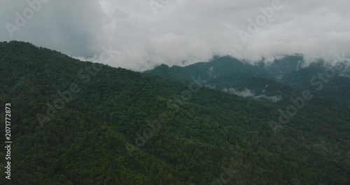 Aerial drone of mountain slopes with tropical forest and jungle covered with clouds. Borneo, Malaysia.