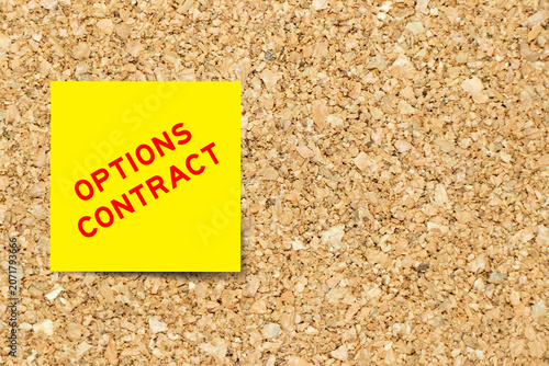 Yellow note paper with word options contract on cork board background with copy space