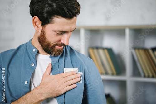 Focus on a money banknotes man putiing in a shirt pocket