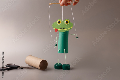 Handmade frog puppet craft made from recycled toilet paper roll. Perfect for kindergarten education, preschool art classes, children creativity blogs, DIY content creators.