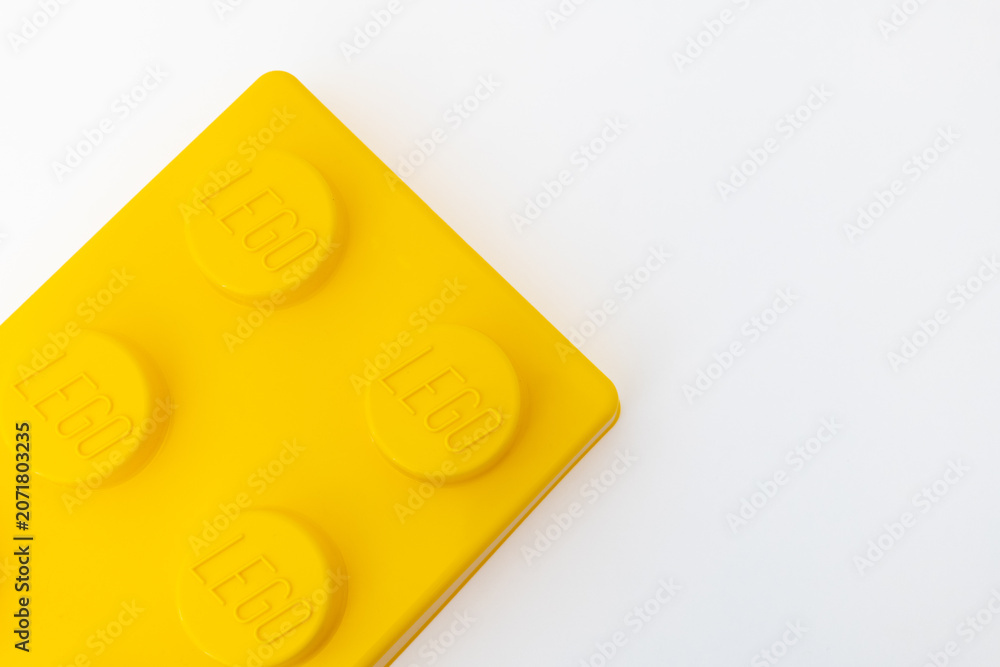 Naklejka premium Bradford, UK June 24 2026 - Close-up of a yellow LEGO storage container lid designed to resemble an ordinary LEGO brick, isolated on a white background with copy space.