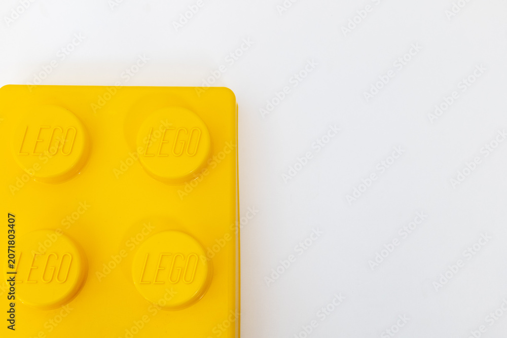 Naklejka premium Bradford, UK June 24 2026 - Close-up of a yellow LEGO storage container lid designed to resemble an ordinary LEGO brick, isolated on a white background with copy space.