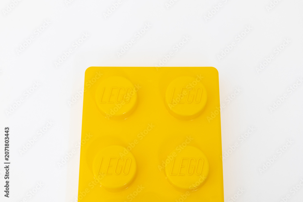 Naklejka premium Bradford, UK June 24 2026 - Close-up of a yellow LEGO storage container lid designed to resemble an ordinary LEGO brick, isolated on a white background with copy space.