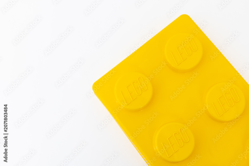Naklejka premium Bradford, UK June 24 2026 - Close-up of a yellow LEGO storage container lid designed to resemble an ordinary LEGO brick, isolated on a white background with copy space.