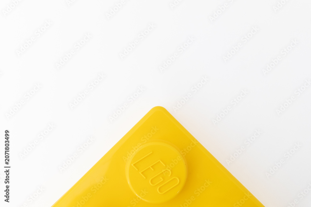 Naklejka premium Bradford, UK June 24 2026 - Close-up of a yellow LEGO storage container lid designed to resemble an ordinary LEGO brick, isolated on a white background with copy space.