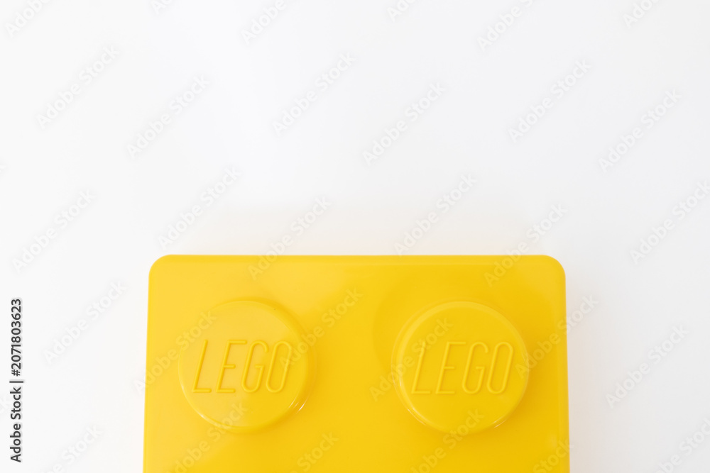 Naklejka premium Bradford, UK June 24 2026 - Close-up of a yellow LEGO storage container lid designed to resemble an ordinary LEGO brick, isolated on a white background with copy space.