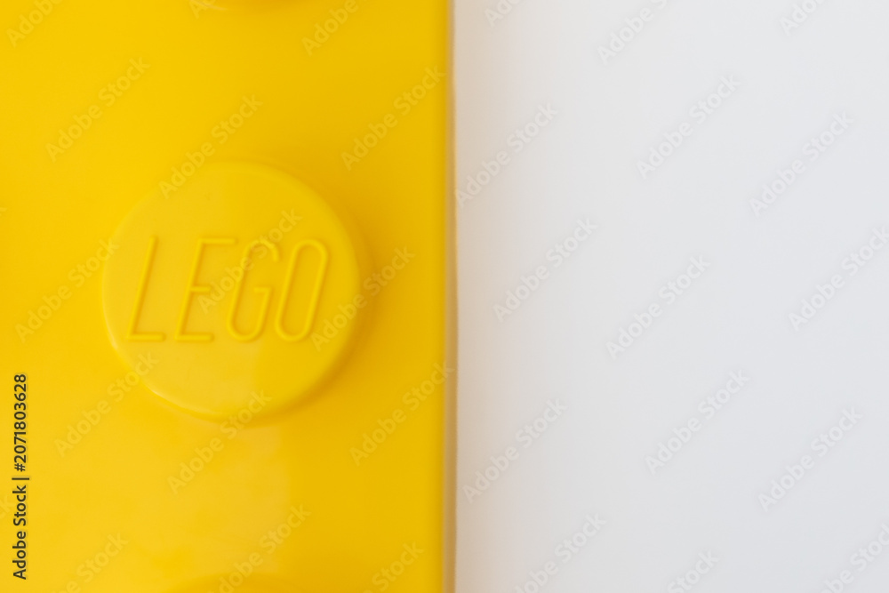Naklejka premium Bradford, UK June 24 2026 - Close-up of a yellow LEGO storage container lid designed to resemble an ordinary LEGO brick, isolated on a white background with copy space.