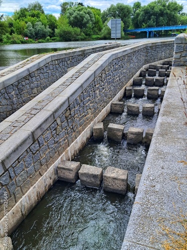 A stone and concrete water fish ladder bypass channel built next to the river dam at Cernosice weir near Bluksky Mill.