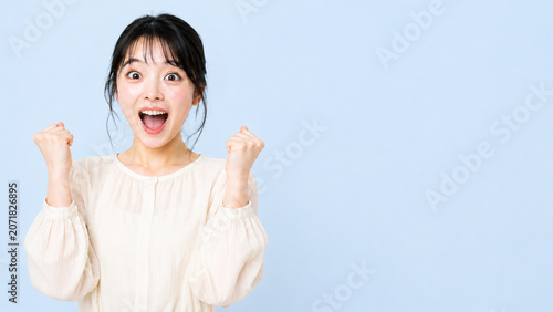 Successful Japanese woman celebrating victory with copy space