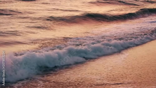 Ocean Serenity: Gentle waves kiss a serene sandy beach at sunset, casting a warm, golden hue across the tranquil seascape. A moment of peaceful reflection beside the vast ocean.