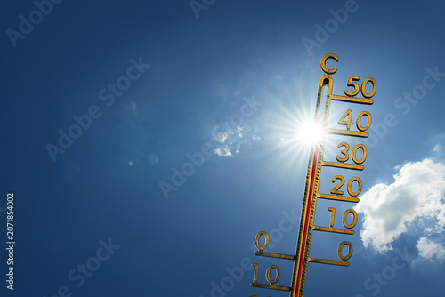 Blue sky on a hot summer day with sun and a thermometer. Extremely hot weather forecast.