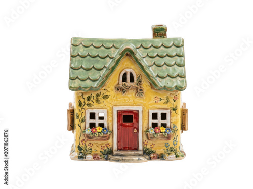 Charming ceramic cottage with green tiled roof and floral embellishments during bright daylight isolated on transparent background