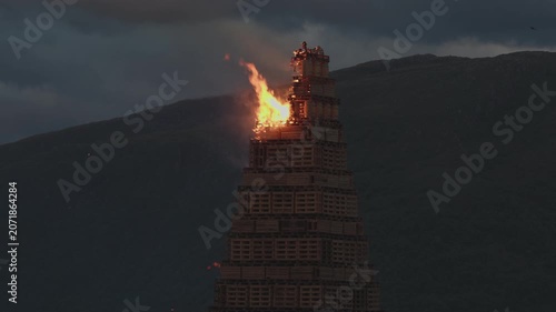 ALESUND, NORWAY, JUNE 20, 2026. Slinningsbalet burns brightly beside the sea in Alesund, Norway, a towering midsummer bonfire reflecting fiery light on dark water on a summer night