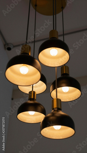 Modern black and gold pendant light fixture cluster.