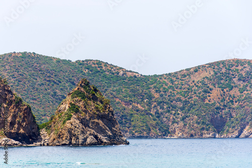 Scenic view of rocky cliffs and turquoise sea on a sunny Mediterranean coastline in Algeria.